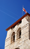 Jerusalem, Israel: Holy Sepulcher church - bell tower, contrails and flag of the Brotherhood of the Holy Sepulchre - Greek T and F, for 'taphos' meaning sepulcher - Christian quarter - photo by M.Torres