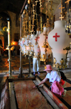 Jerusalem, Israel: Holy Sepulcher church - lamps and woman praying at the Stone of Anointing, aka the Stone of Unction, claimed to be the spot where Joseph of Arimathea prepared Jesus' body for burial - Christian quarter - photo by M.Torres