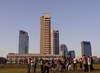 Lithuania - Vilnius: young people dancing near the river Neris - business district towers - photo by Sandia