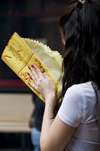 Kuala Lumpur, Malaysia: woman with paper offerings praying at Guandi Temple - photo by J.Pemberton