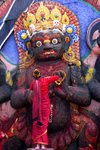 Kathmandu, Nepal: woman making offering to Kala Bhairab statue in Durbar square - 17th century stone image - photo by J.Pemberton