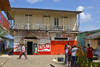 A group of kids chat as an adult passes by, in front of a small town saloon. Portobello, Coln, Panama, Central America - photo by H.Olarte