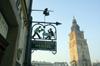 Poland - Krakow: restaurant sign and Town Hall tower - photo by M.Gunselman