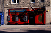 Scotland - Edinburgh: this clever sign is a takeoff on the nearby street Canongate - vibrant colors in the storefront - 'The Canon's Gait' - photo by C.McEachern