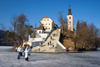 Slovenia - View across to the island church on Lake Bled in Slovenia when frozen over in winter with people walking across ice - photo by I.Middleton