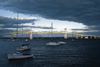 Narragansett Bay, Rhode Island, USA: boats and Claiborne Pell Newport Bridge, suspension bridge over the Atlantic Ocean - links Newport on Aquidneck Island and the Jamestown on Conanicut Island - stormy sky at sunset - photo by C.Lovell