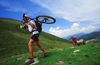 Chamonix, Haute-Savoi, Rhne-Alpes, France: a mountainbiker carrying his bike on the trail while other negotiates passage with a sheep - photo by S.Egeberg